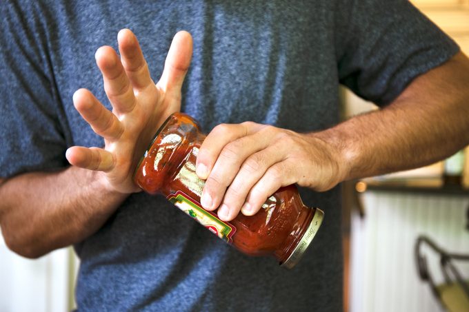 man using the water hammer technique to open a jar