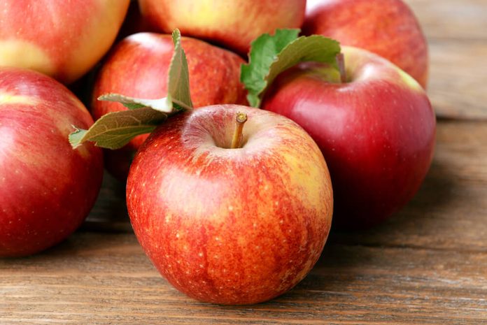 Ripe red apples on wooden background