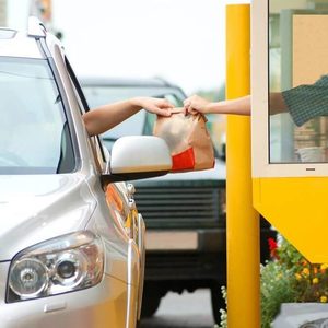 Fast food bag being handed out of a drive-thru window
