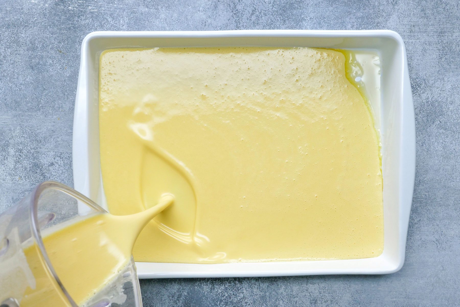 Batter of eggs milk, flour poured in a baking dish to make German Pancakes