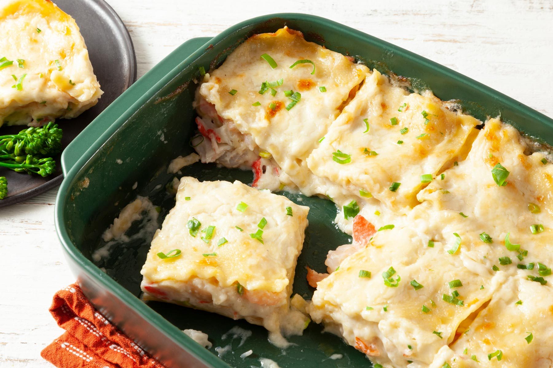 A Green Dish With Lasagna in it