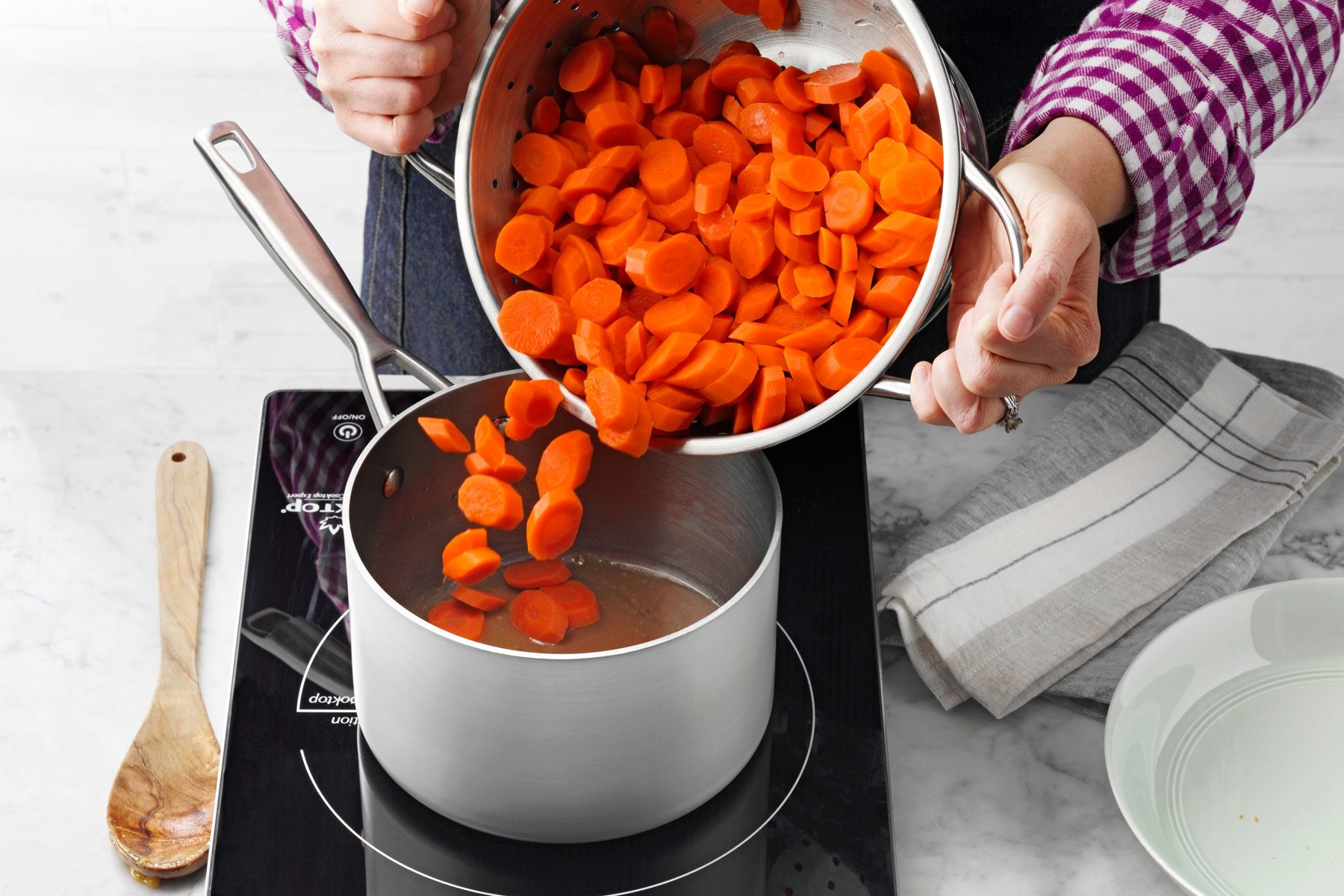 A Person Pouring Carrots Into a Pot