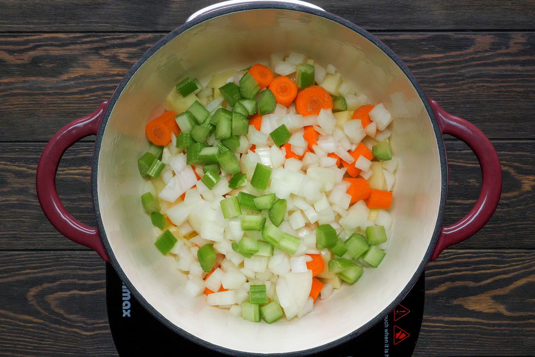 Potatoes, carrots, onion in a large pan is cooked to make Turkey Potpies