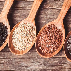 Chia and flax seeds, white and black sesame in wooden spoons