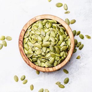 Raw pumpkin seeds, food background, top view