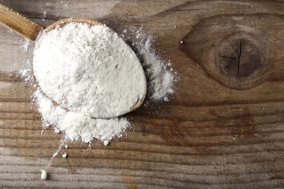 Organic wheat flour in wooden spoon