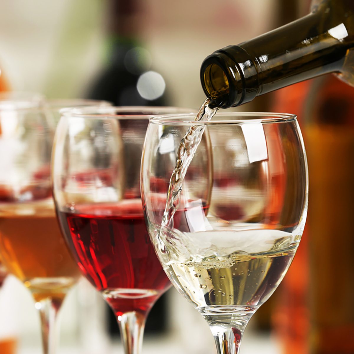 White wine pouring into glasses, closeup