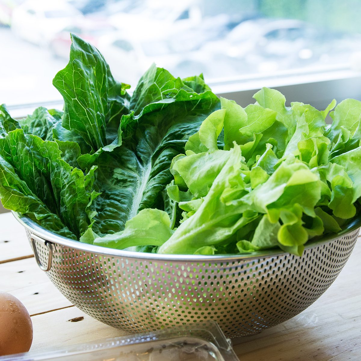 Green leafy vegetables with eggs on wooden background