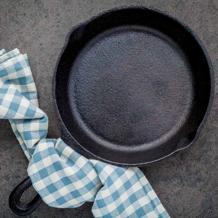 Empty cast iron skillet frying pan flat lay on dark stone background