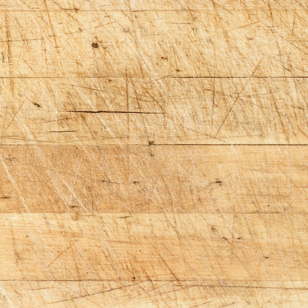 Old and used natural wooden cooking board with cuts