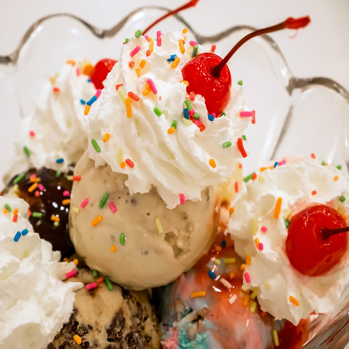 Ice cream scoops with cherry and whipped cream.