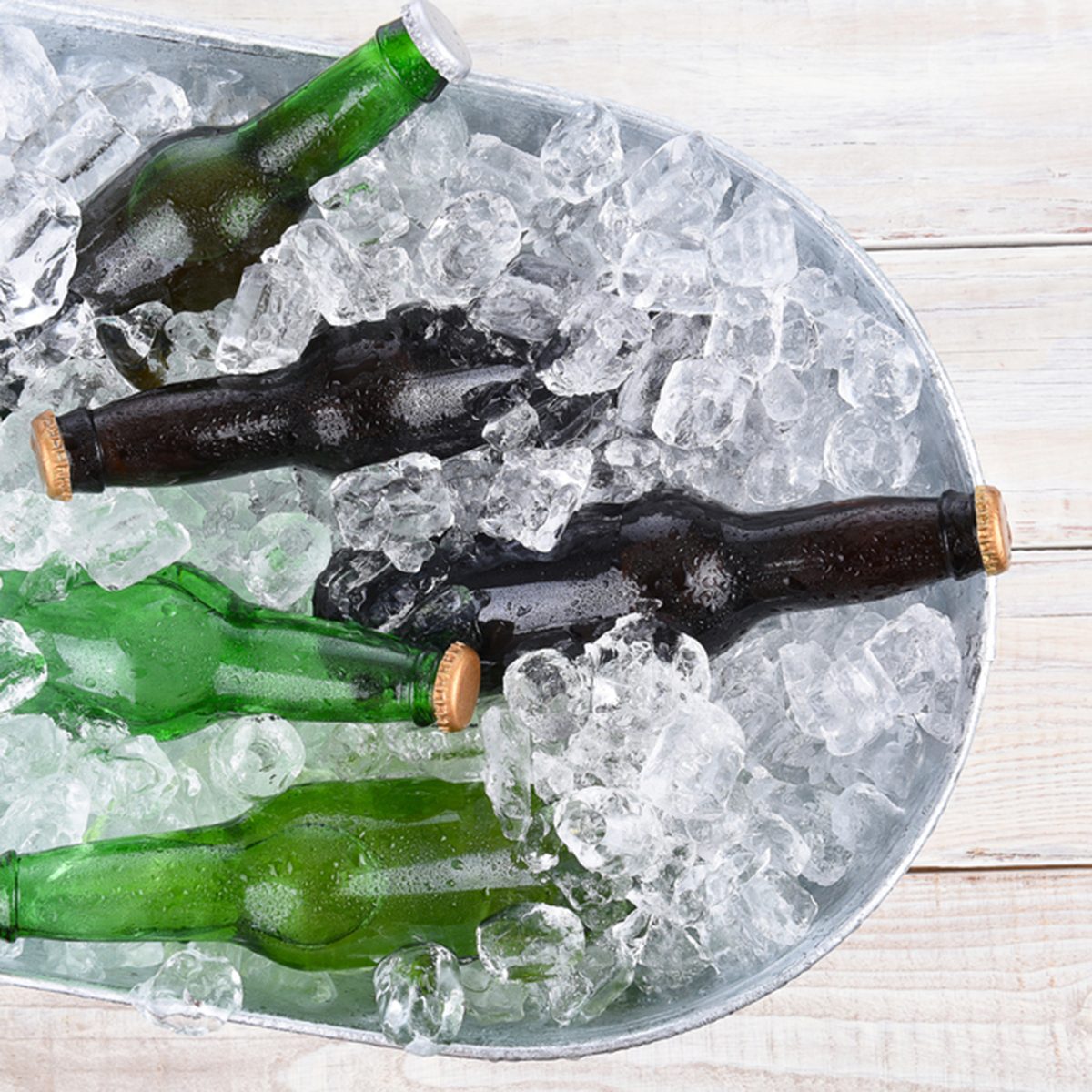 High angle view of a beer bucket filled with ice and assorted beer bottles.