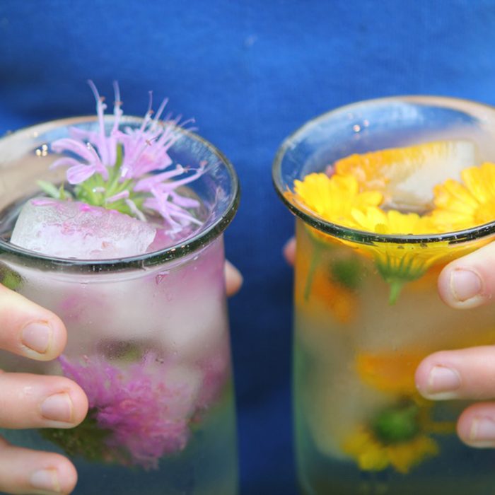 Woman holding a drink in each hand