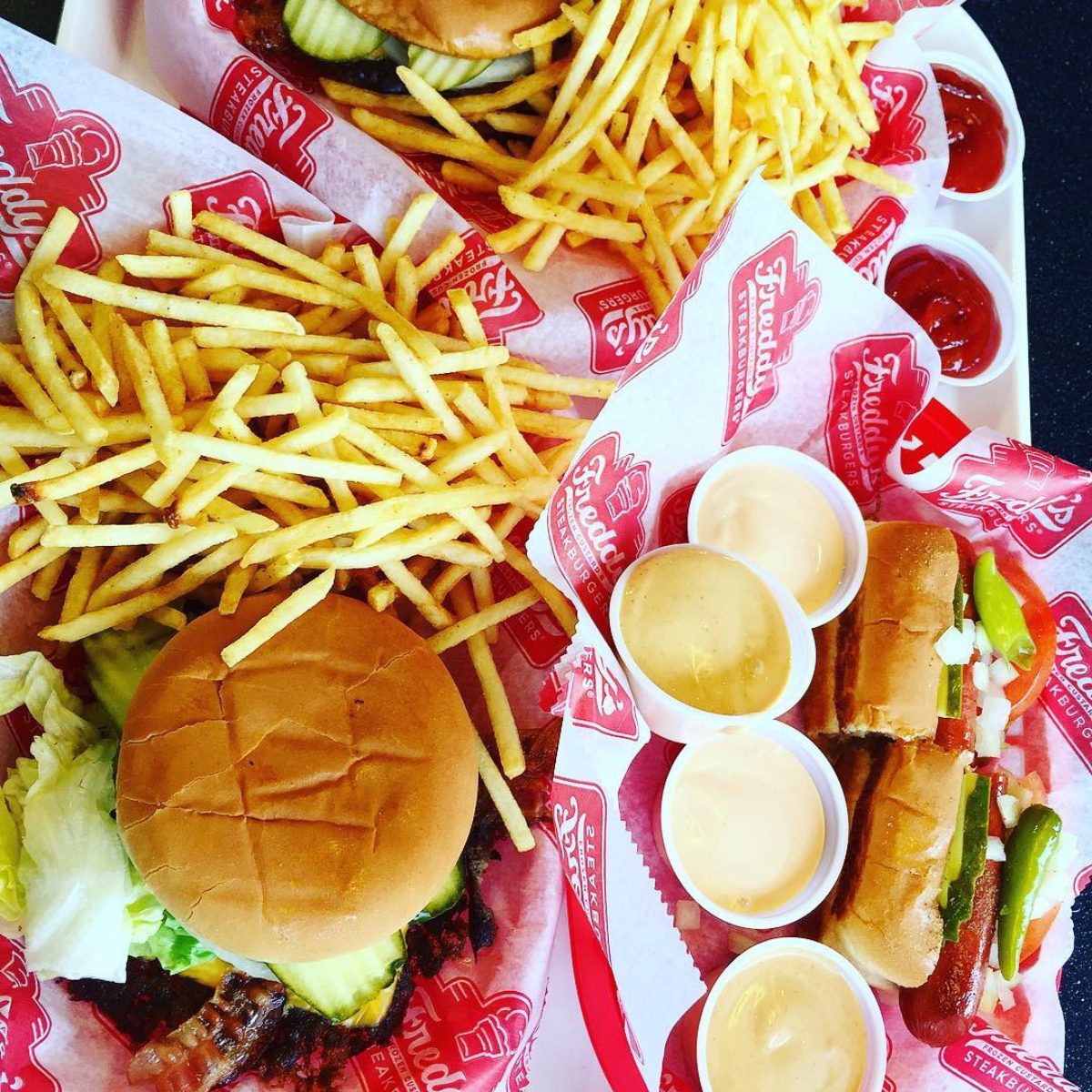 Burger, fries and sauces on a paper wrapper