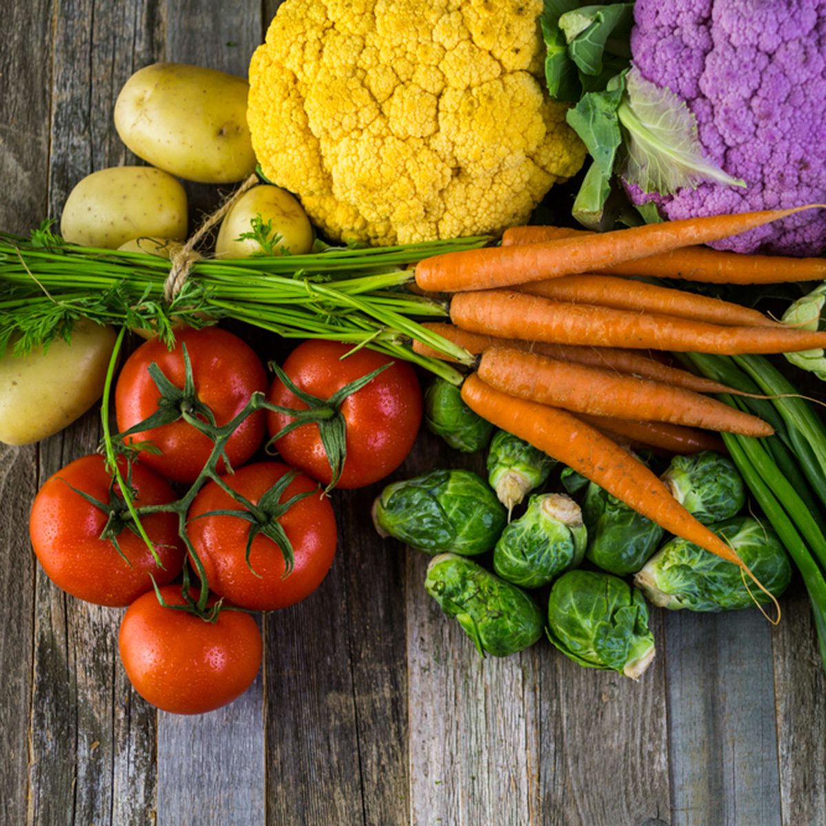 Fresh organic vegetable in season on old farm table.