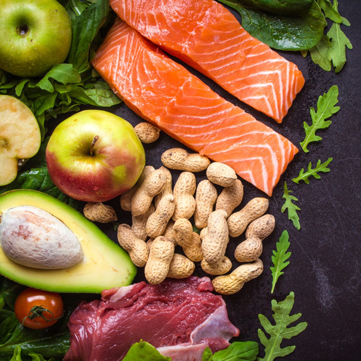 Fresh vegetables, fruits, fish, meat, nuts on black chalk board background.