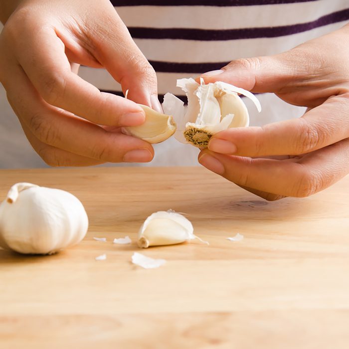Woman peeling garlic by hand for cooking