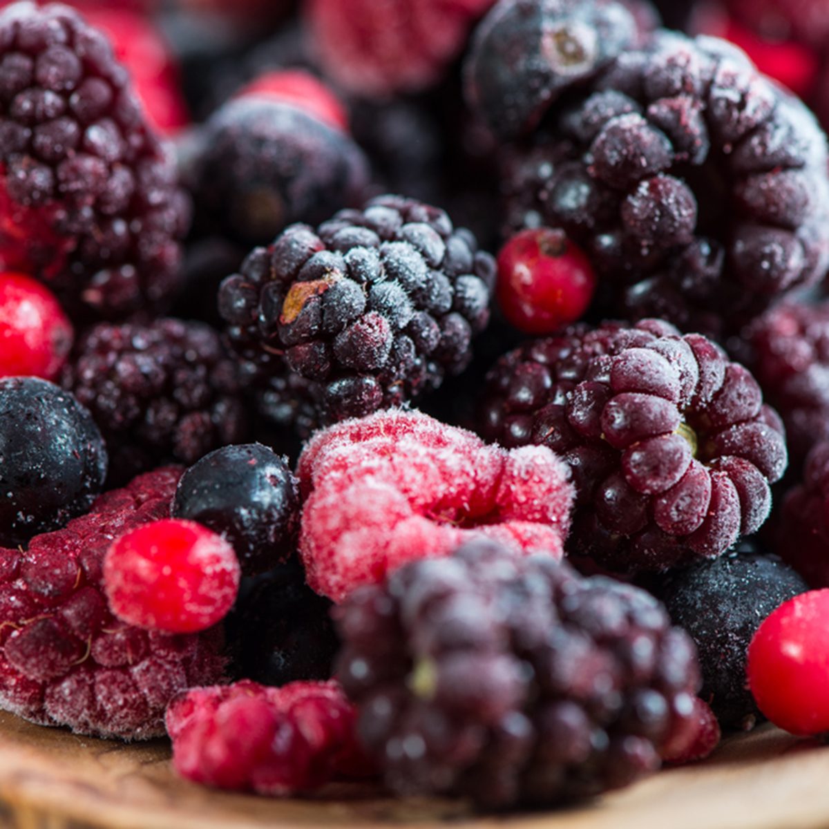 mixed frozen berries on wooden background