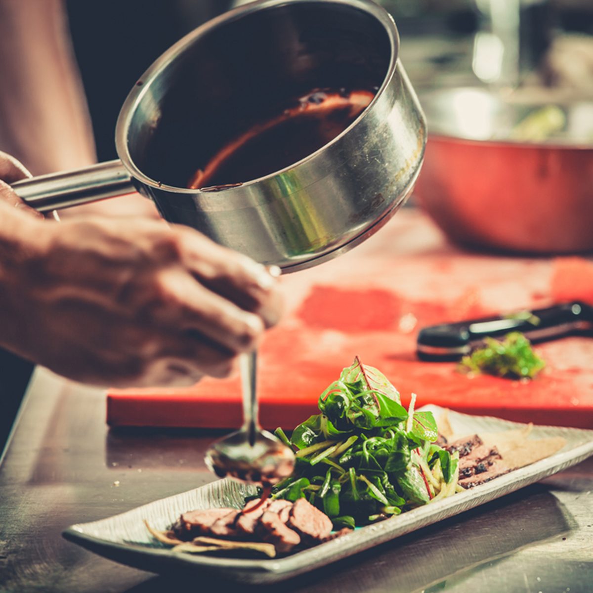 Chef finishing her plate and almost ready to serve at the table.
