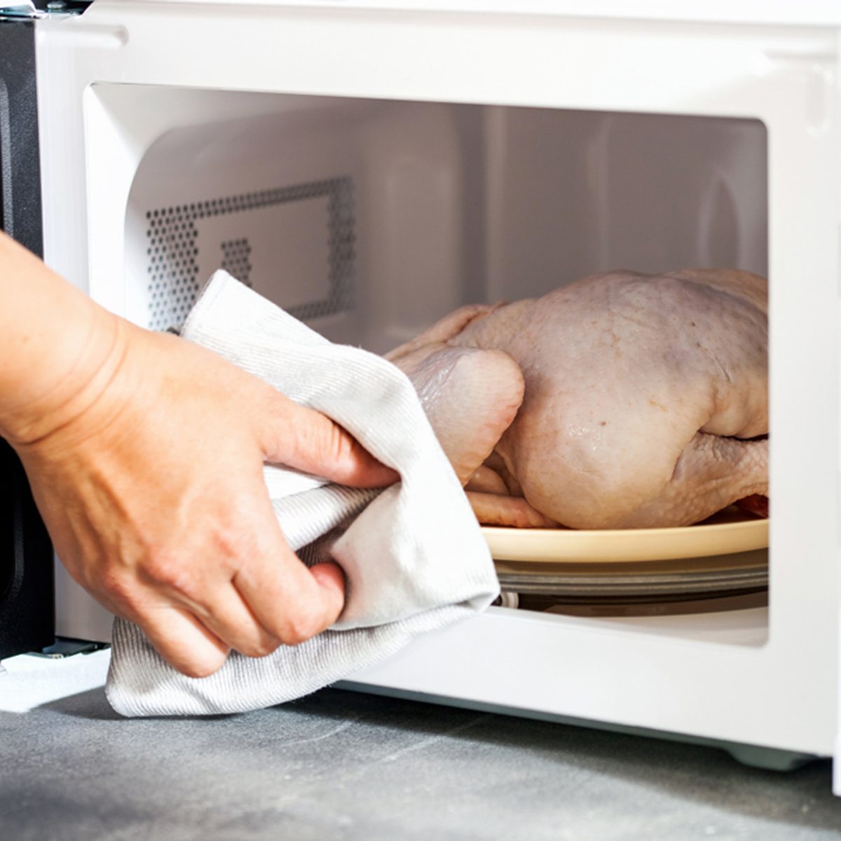 The defrozen raw chicken in the microwave.