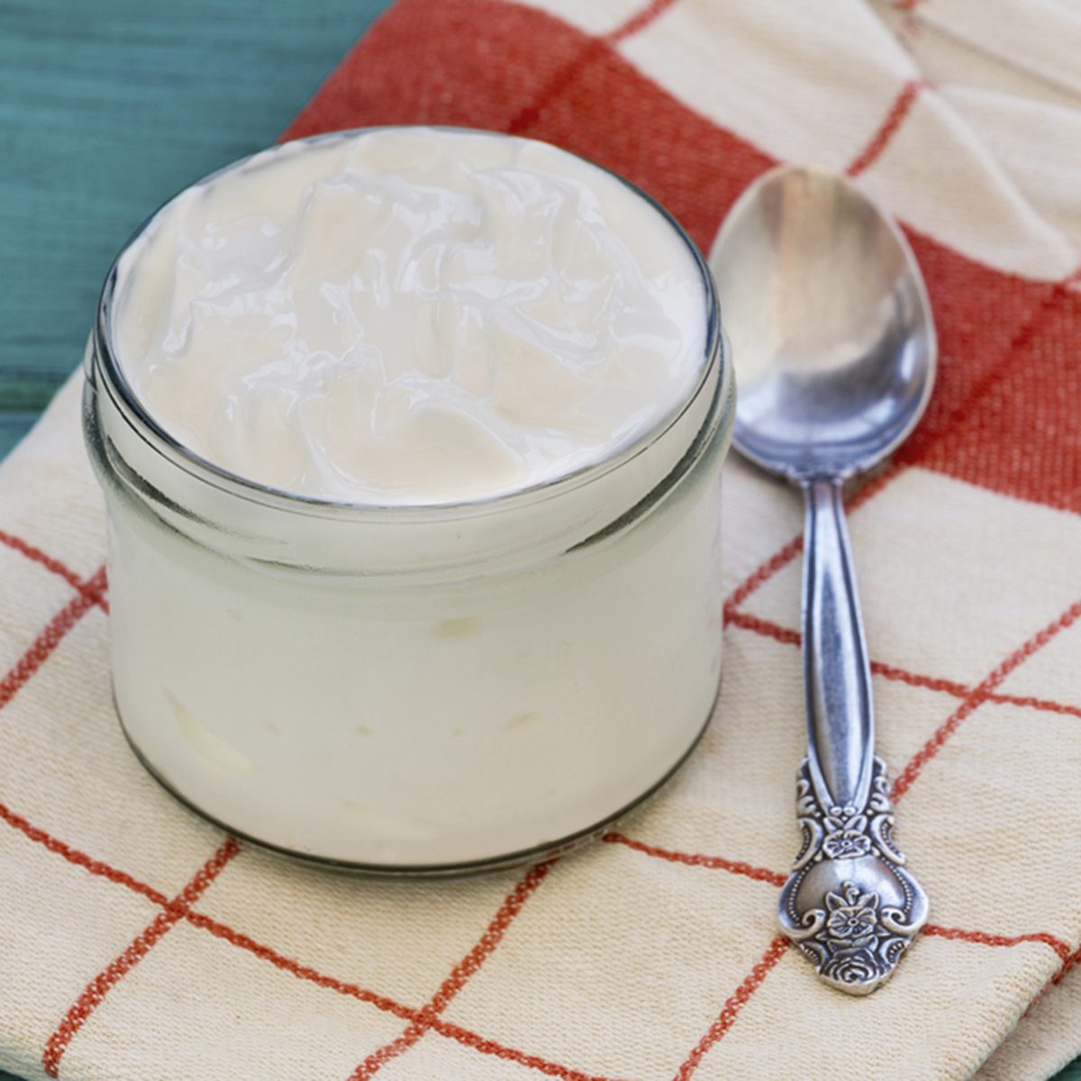 Greek Yogurt or Plain Yogurt and a spoon on a vintage wood background.
