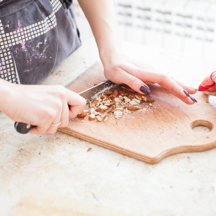 The concept of cooking. The confectioner cuts the almonds for the cake.; Shutterstock ID 1059938054; Job (TFH, TOH, RD, BNB, CWM, CM): Taste of Home