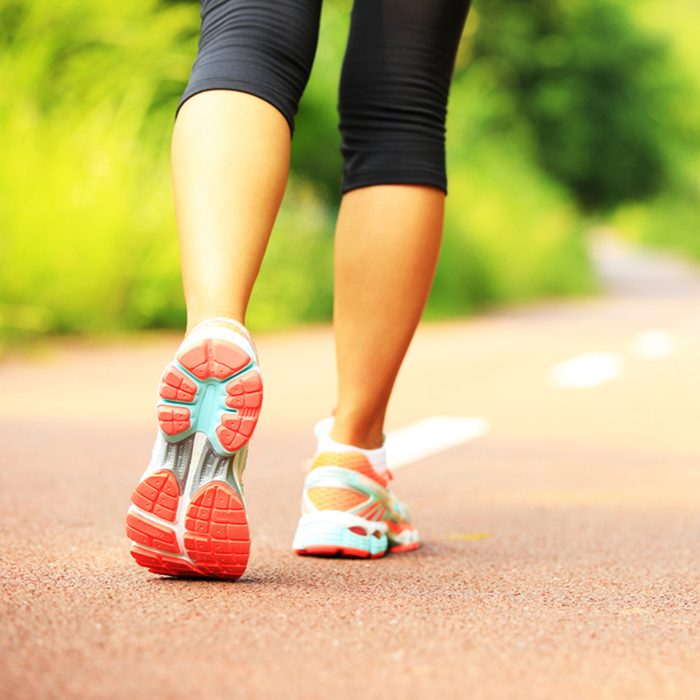 young fitness woman hiker legs at forest trail