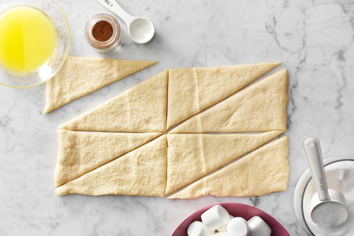 rolling out dough and cutting into triangles