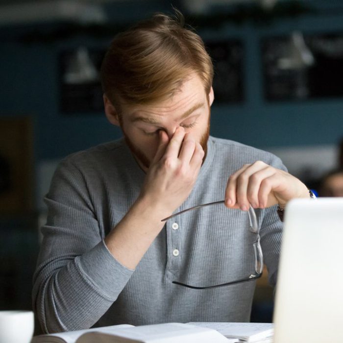 Man pinching bridge of his nose