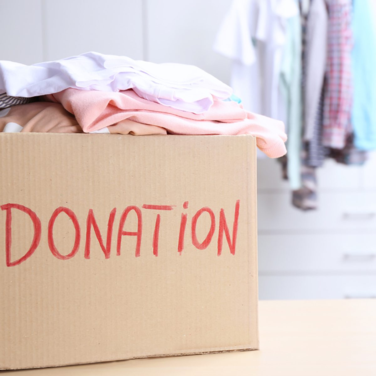 Donation box with clothes on table in the room