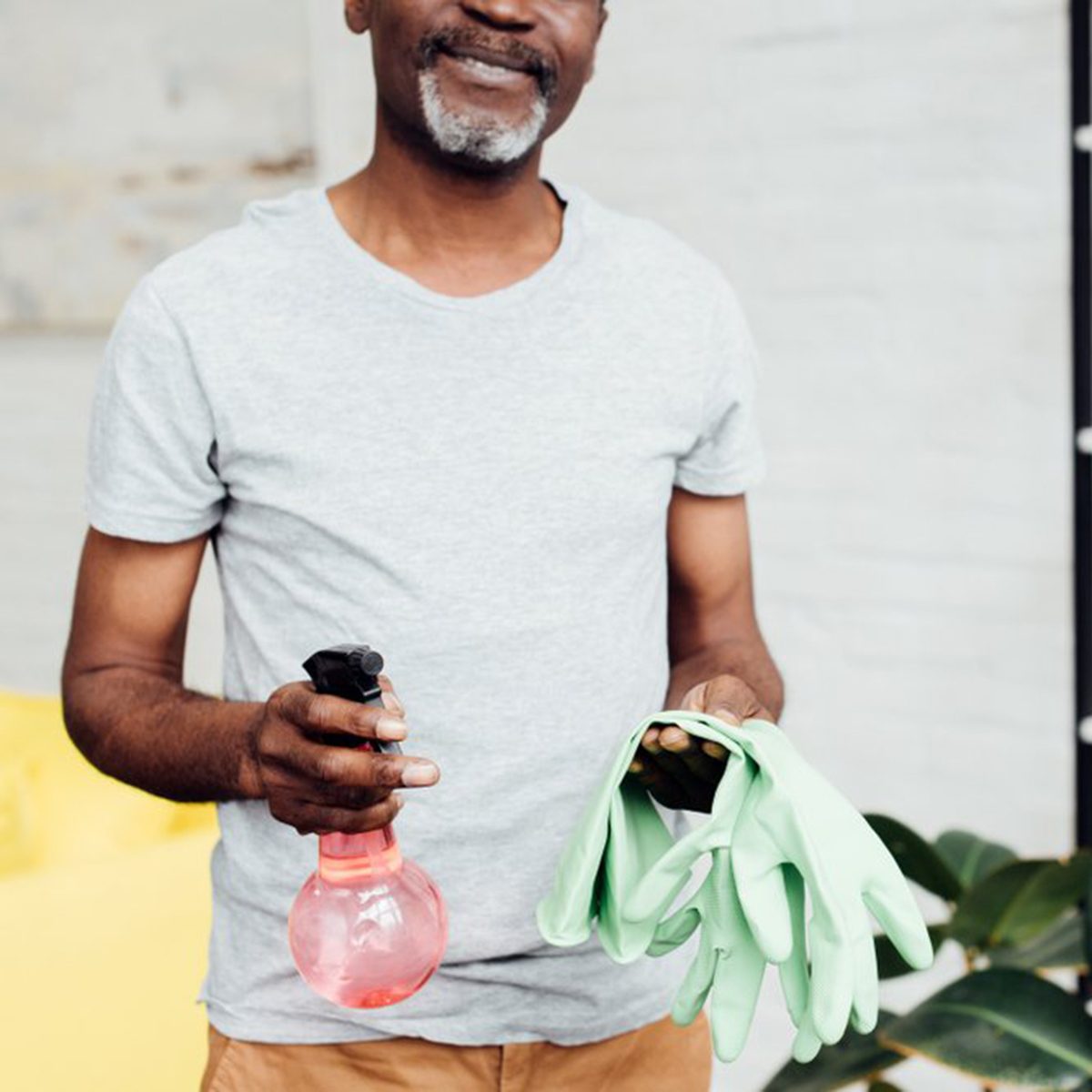 Man holding cleaning supplies and smiling