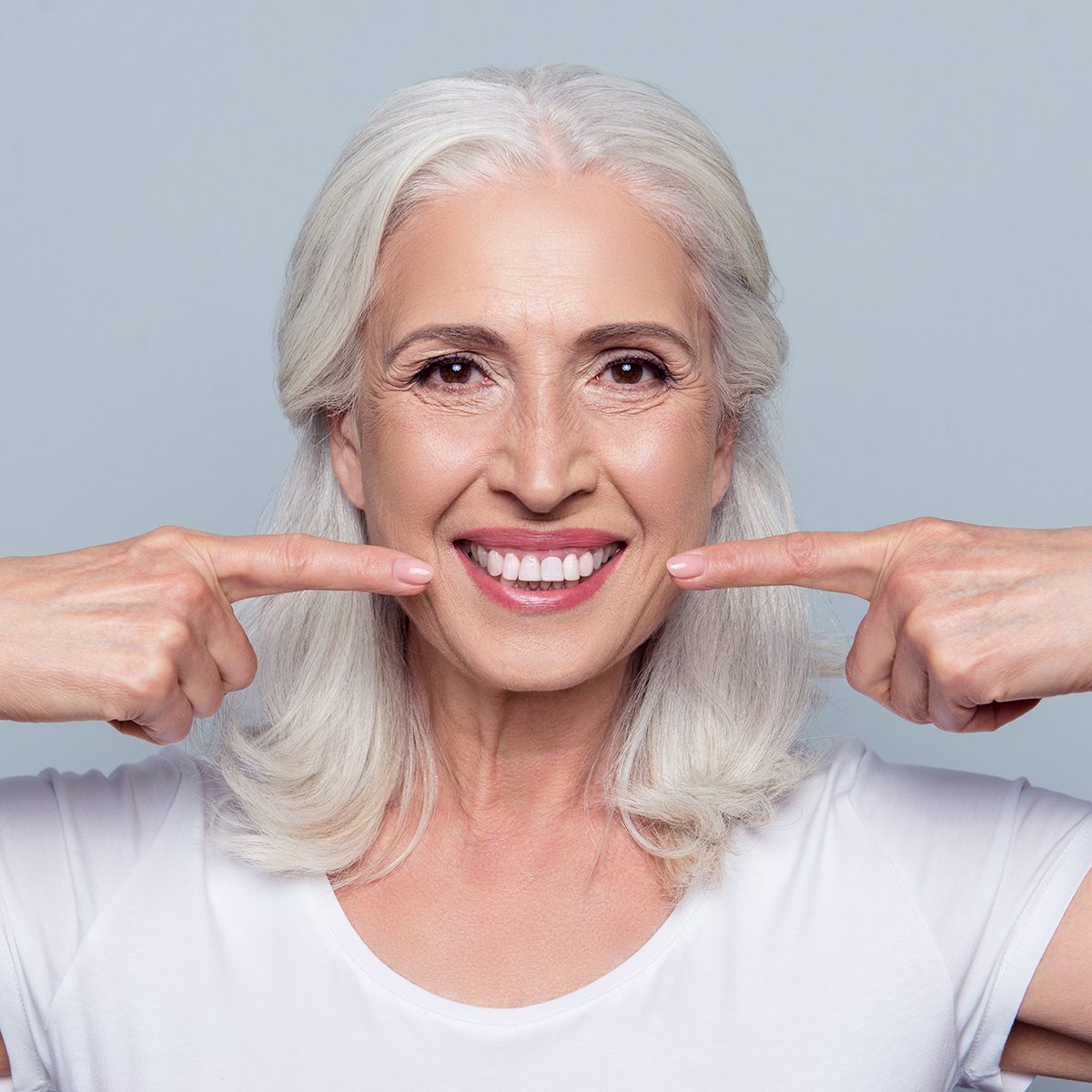 Concept of having strong healthy straight white teeth at old age. 