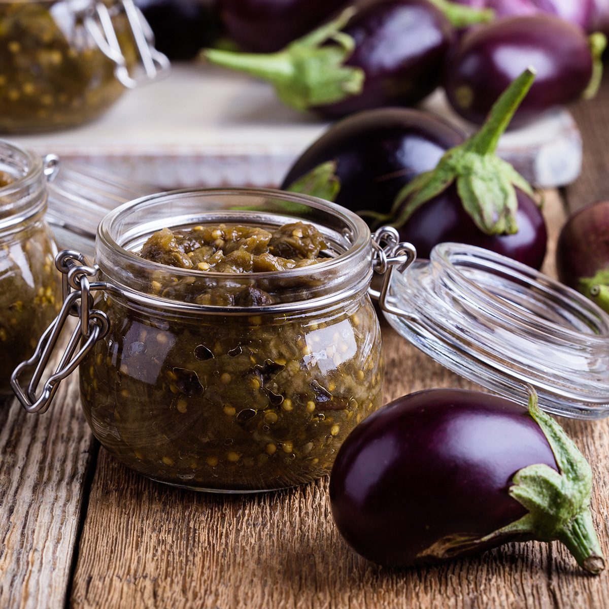 Eggplant preserves. Homemade vegetarian vegetable caviar in glass jar on rustic wooden table