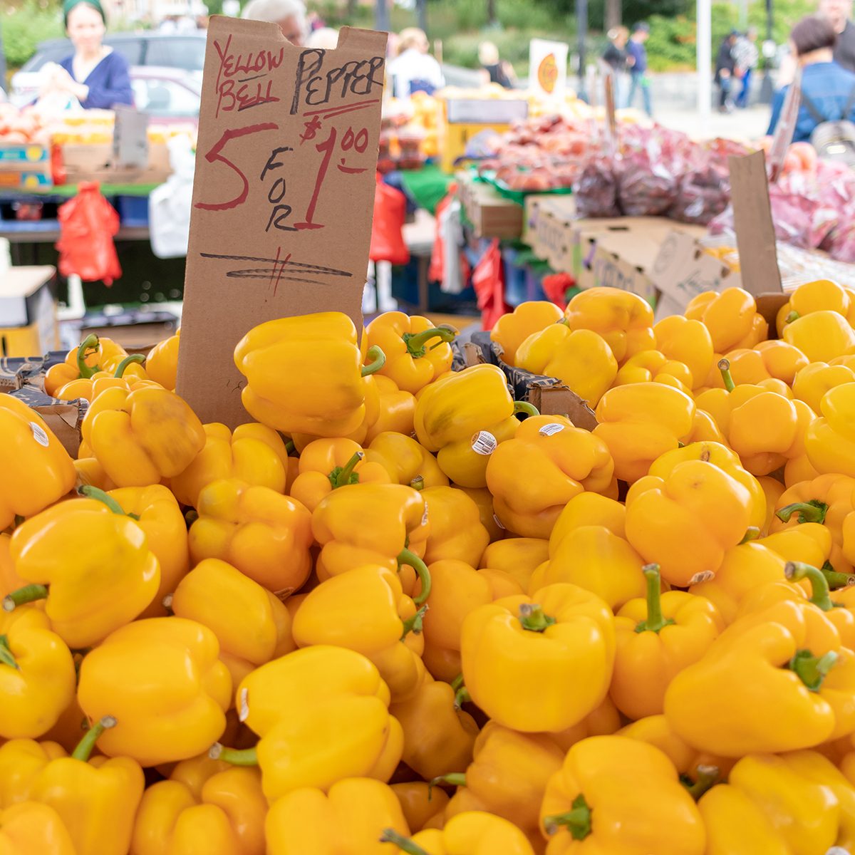 yellow bell peppers for sale at an outdoor farmer