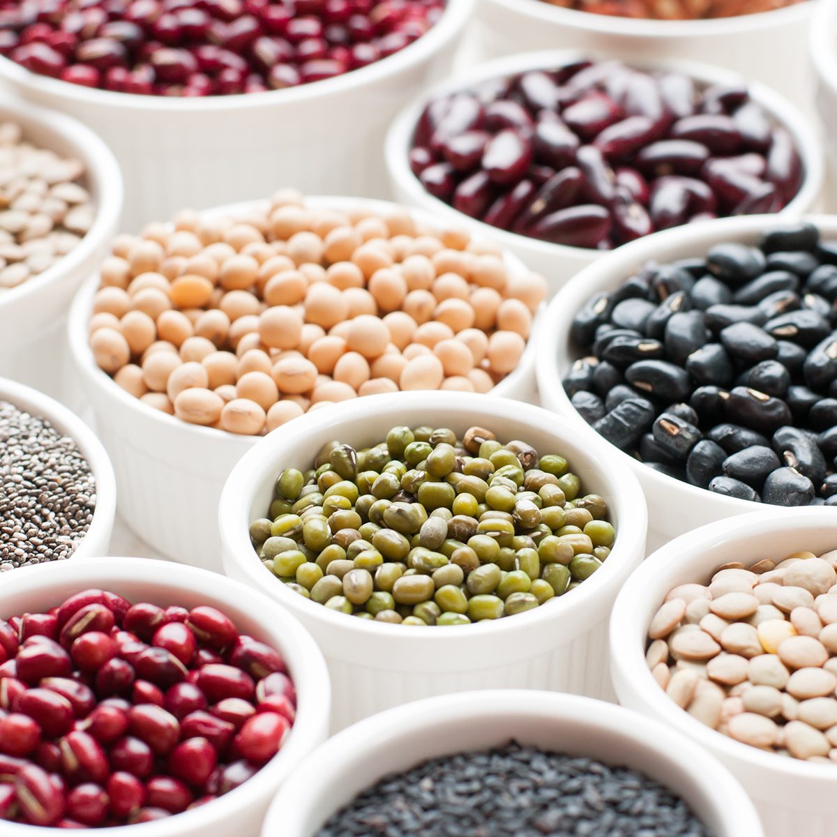 collection set of beans, legumes, peas, lentils on ceramic bowl on white wooden background