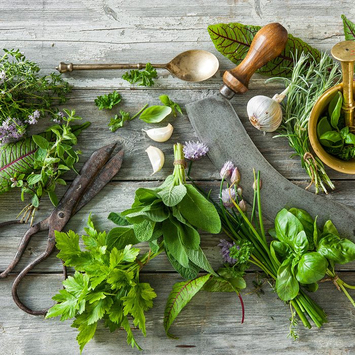 fresh kitchen herbs and spices on wooden table.