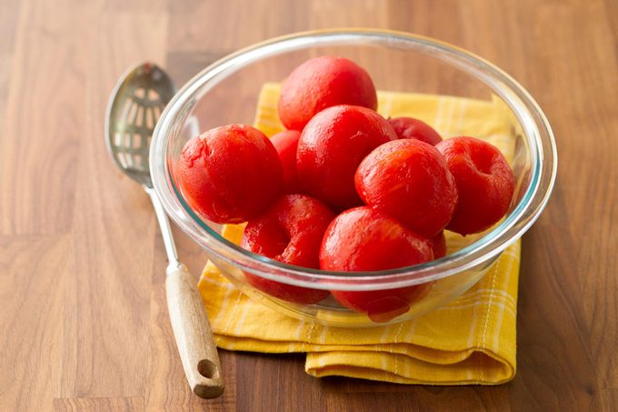 peeled tomatoes in glass bowl