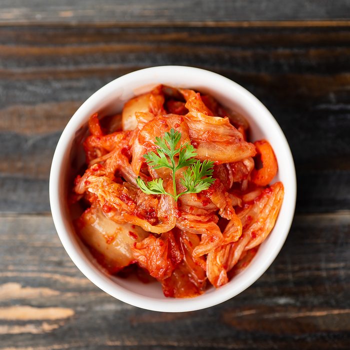 Kimchi cabbage in a bowl on wooden background