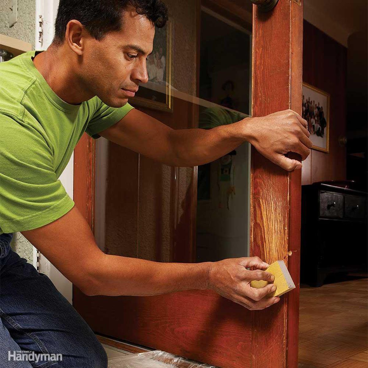 Man wiping over claw marks in a door
