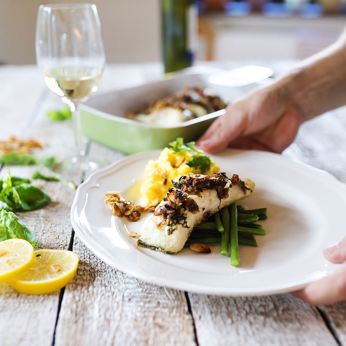 Man serving zander fish fillets on a plate