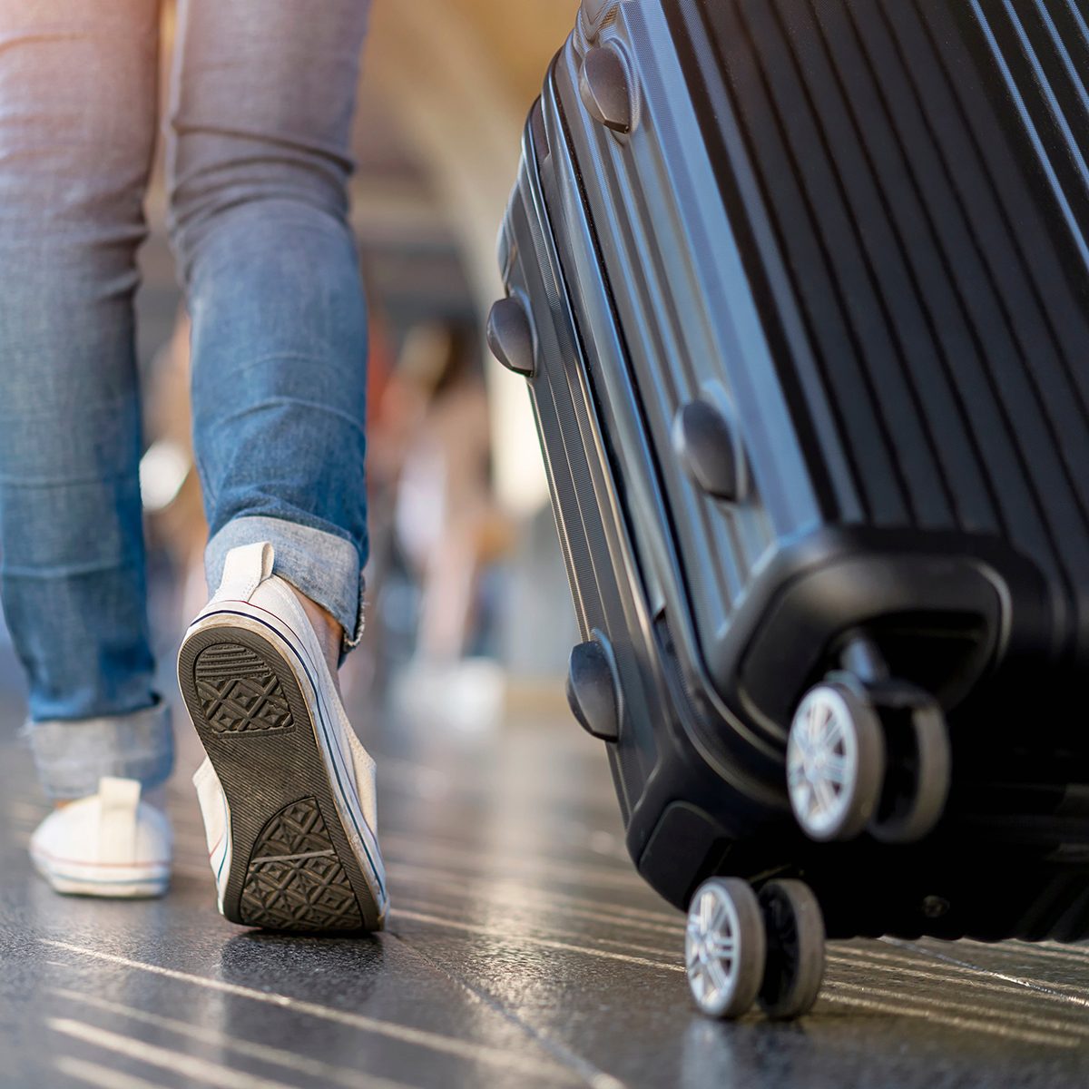 Person wheeling luggage through airport