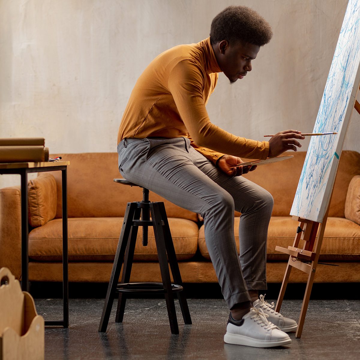 Young man painting a canvas