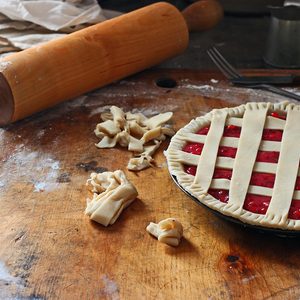 Vintage homemade pie making mess with bright red fruit