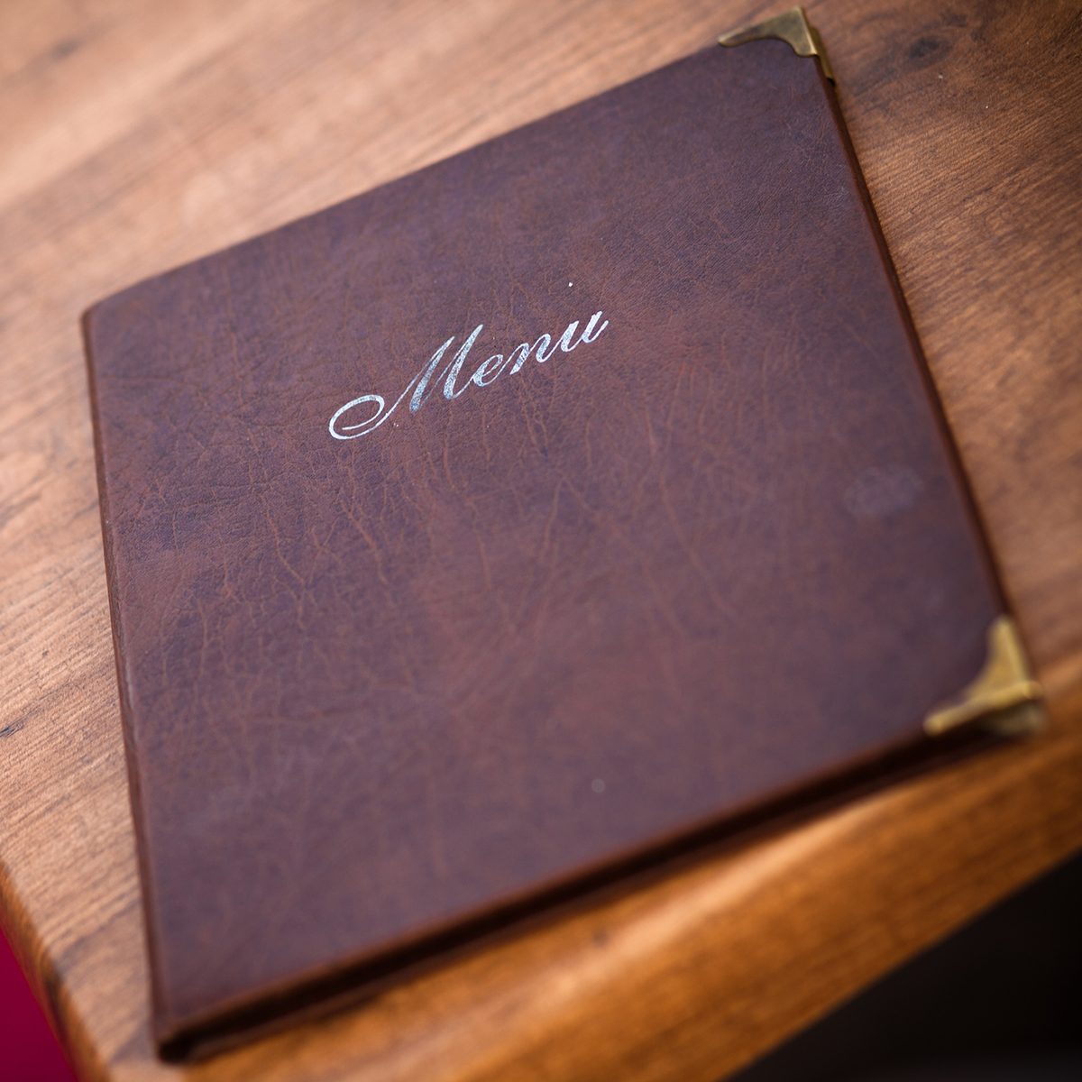 A beautifully-worn leather-bound menu at a European cafe in Prague, Czech Republic