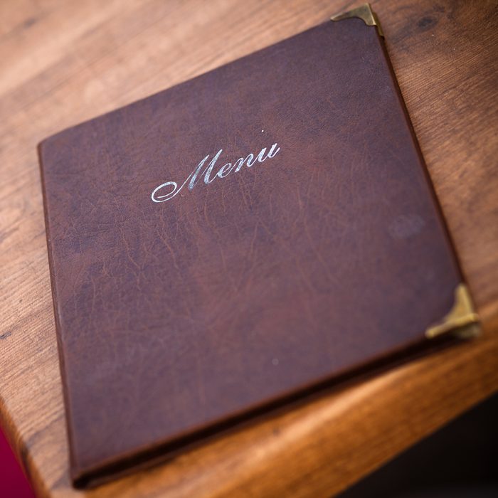 A beautifully-worn leather-bound menu at a European cafe in Prague, Czech Republic