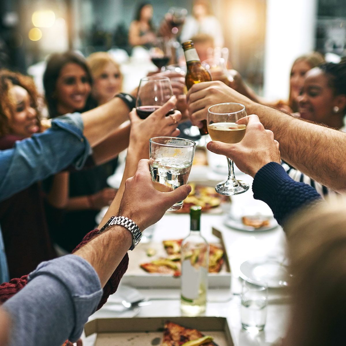 Cropped shot of a group of young friends toasting during a dinner party at a restaurant