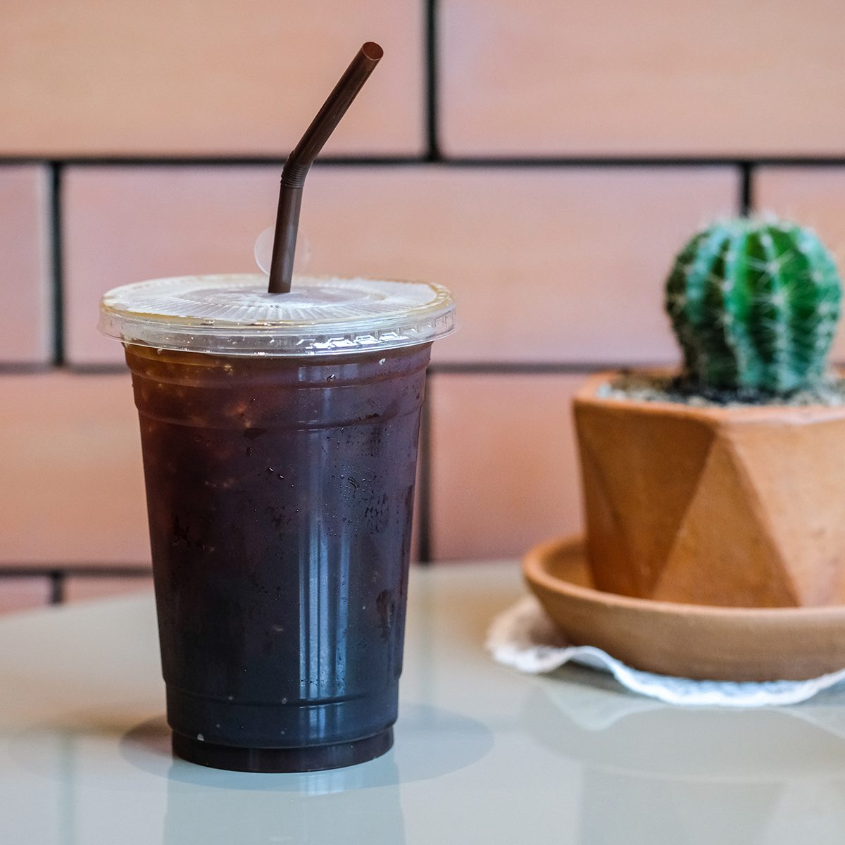 Long black coffee with ice on wooden table in coffee shop