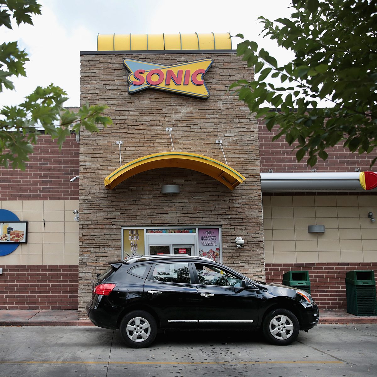 CHICAGO, IL - SEPTEMBER 25: A customer picks up food at the drive-up window at a Sonic restaurant on September 25, 2018 in Chicago, Illinois. Inspire Brands Inc., the parent company of Arby