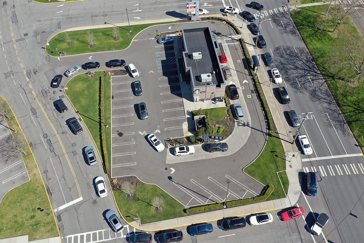 HICKSVILLE, NEW YORK - MAY 02: In this aerial image from a drone, the line for the drive-in window at at Starbucks wraps around the building and on to the main road on May 2, 2020 in Hicksville, New York. Restaurants continue to keep their dining rooms closed and have relied on deliveries and pick up windows due to the coronavirus pandemic. (Photo by Bruce Bennett/Getty Images)