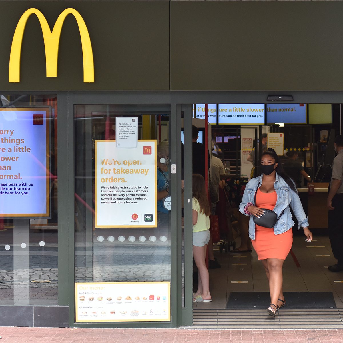 SOUTHEND-ON-SEA, ENGLAND - JULY 24: A customer wearing a face mask walks out of a McDonalds restaurant on July 24, 2020 in Southend on Sea, England. From today, consumers in the United Kingdom must wear face coverings in enclosed public spaces including shops, takeaways and public transport hubs. (Photo by John Keeble/Getty Images)